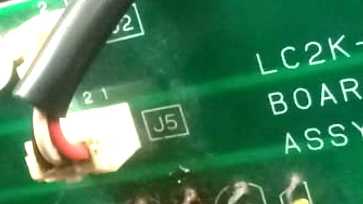 Close-up of J5 and the row of components beneath it containing the failed fan-detection transistor.